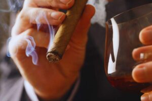 mani fumano sigaro e bevono