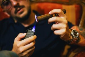 un uomo accende un sigaro