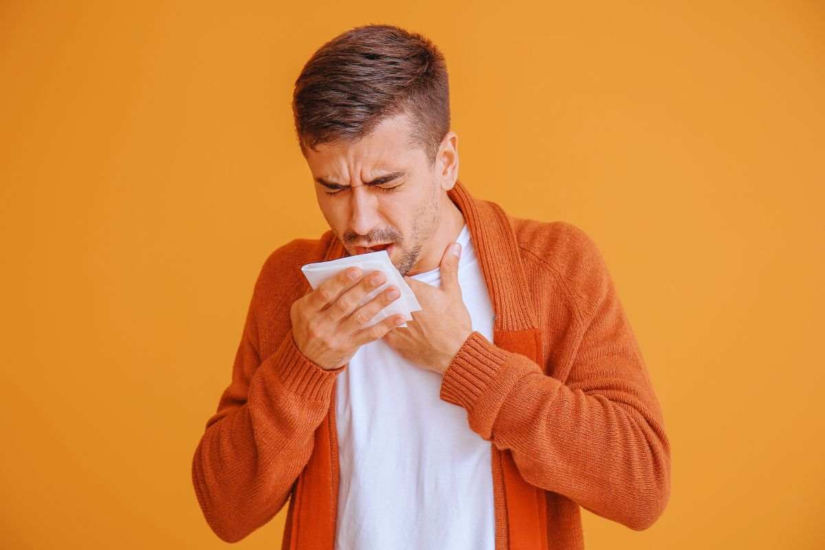 ragazzo tossisce col fazzoletto in mano